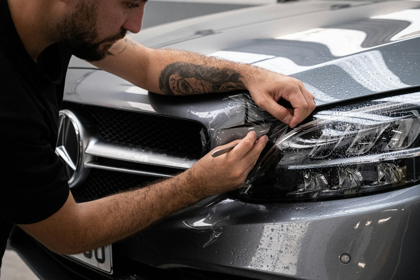 Mike installing paint protection film by hand, Precise Detailing bay