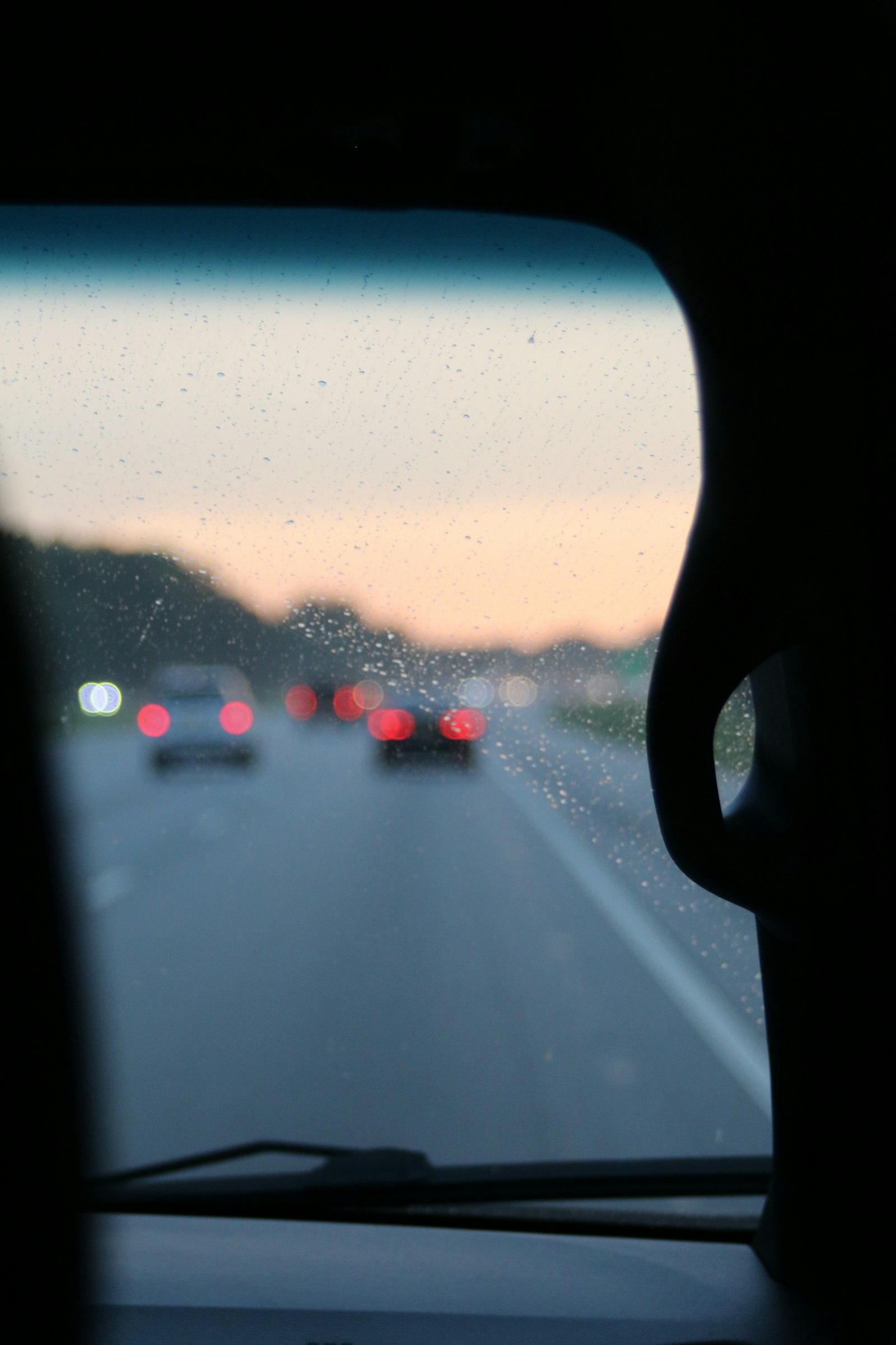 Water beads rolling off a coated vehicle windshield